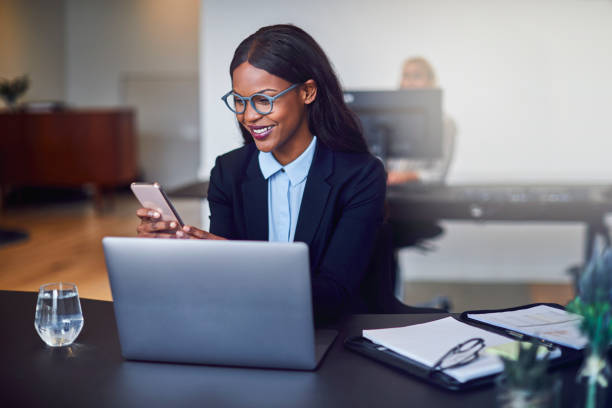 istock Smiling African American businesswoman reading cellphone texts at work 1158395929