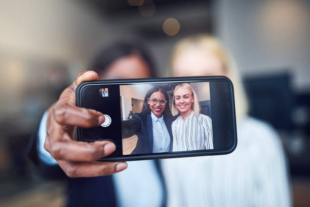 istock Smiling businesswoman using a cellphone to take selfies together 1158396408