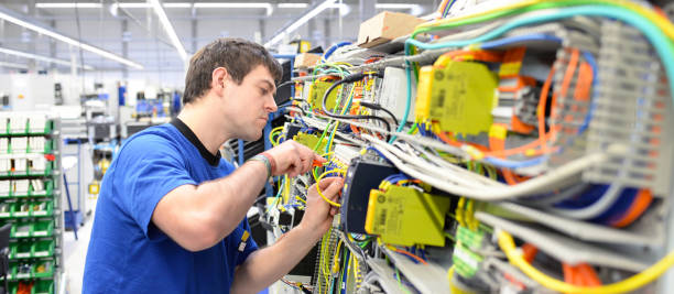 istock young operator assembles machine in a modern high tech factory - production of switch cabinets for industrial plant 1158397395