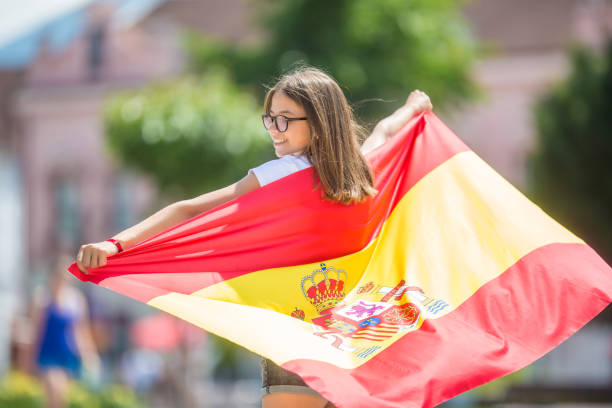 glückliches mädchen tourist zu fuß in der straße mit spanischer flagge. - catalonia success confidence flag stock-fotos und bilder