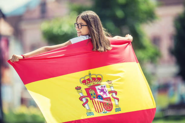 glückliches mädchen tourist zu fuß in der straße mit spanischer flagge. - catalonia success confidence flag stock-fotos und bilder