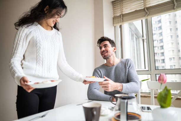 istock Asian woman serving breakfast to man 1158402796