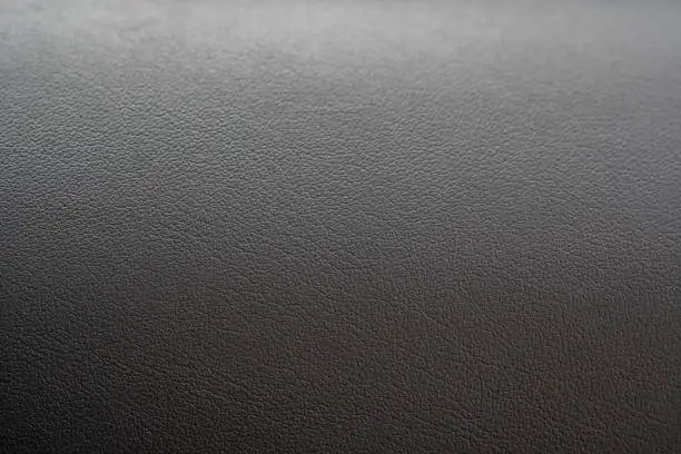Photo of Dashboard surface of a car. Leather texture.