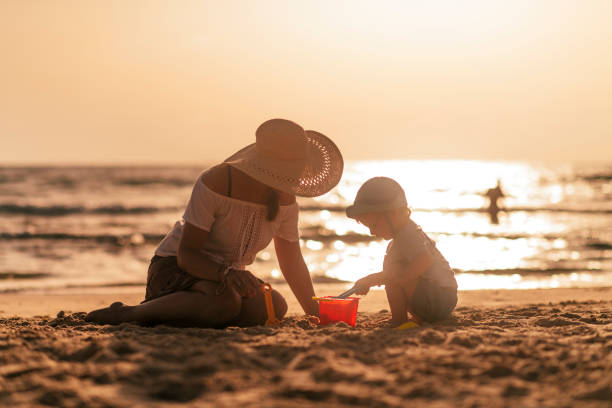 istock Mother and son on the beach playing with sand 1158407781