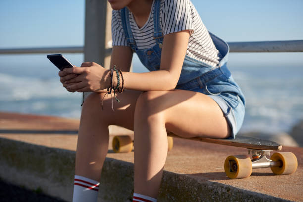 istock young woman using her phone texting outdoors 1158408757