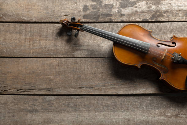 istock Violin on a wooden textured table 1158415788