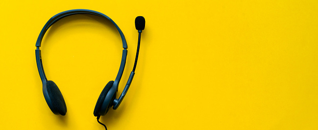 close up top view of headset of call center and VOIP for communication technology on yellow background for network operation job concept