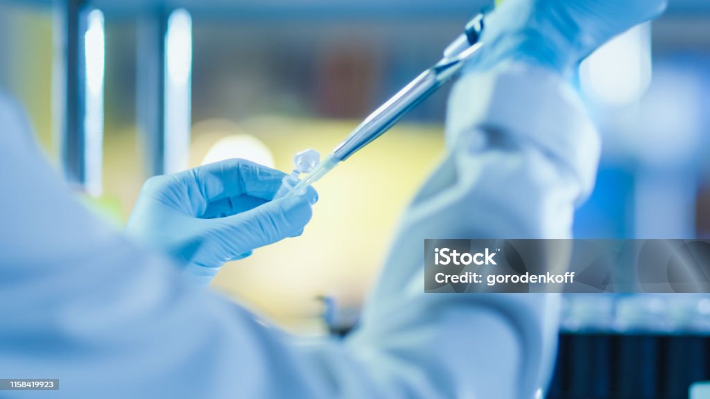 Close-up Shot of a Research Scientist using a Micro Pipette in a Modern Genetic Laboratory. Laboratory Stock Photo