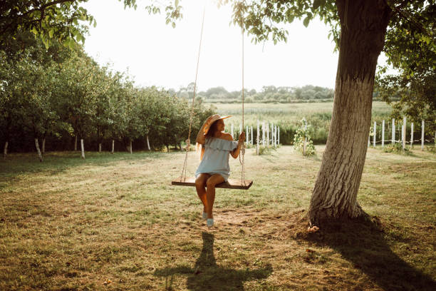 istock Beautiful woman enjoying on a swing 1158420901