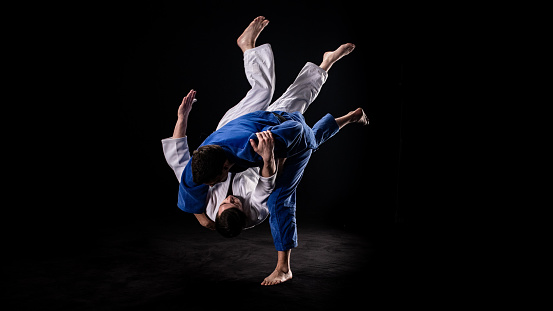 Photo of a judo practitioner throwing his sparring partner to the ground.