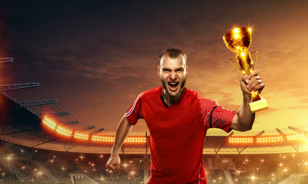 istock Soccer player celebrates victory and holds a trophy 1158422387