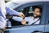 Happy businessman receiving keys of his new car.