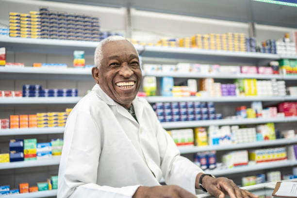 porträt des apothekers in einer drogerie - pharmacy pharmacist smiling pill stock-fotos und bilder