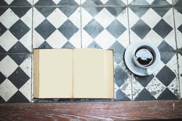 istock Cup of coffee and book on wooden table, top view 1158424724