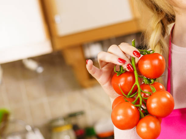 istock Woman hand holding tomates 1158424785