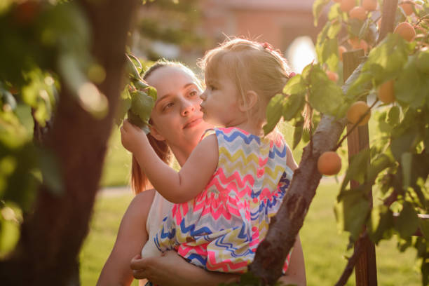 istock Mother and child in the orchard. 1158424981