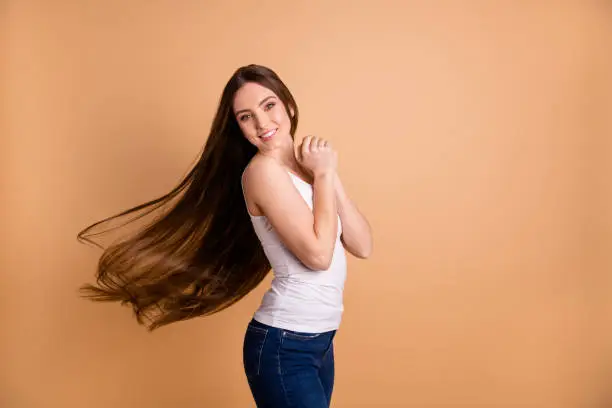 Close up side profile photo beautiful her she lady hands arms together, overjoyed weather warm wind breeze hair flight inspired wear casual white tank-top jeans denim isolated pastel beige background