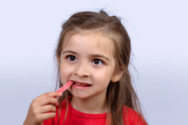 istock Little girl eating sweet candy. 1158431981