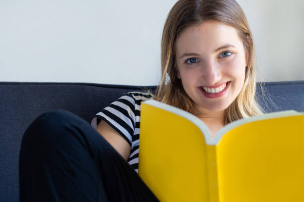 istock Woman reading a book at home 1158432008