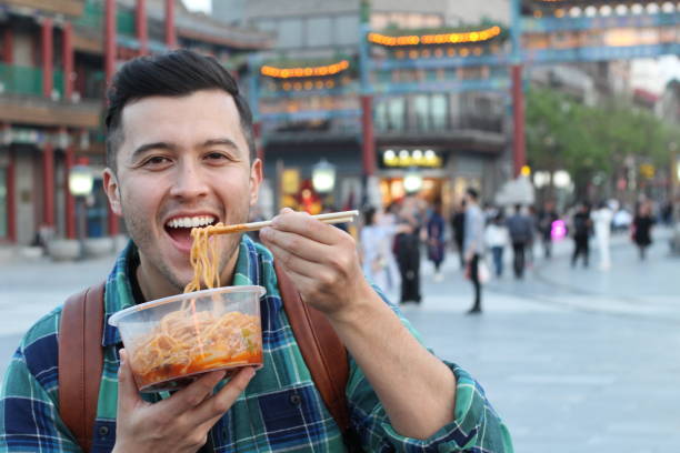 istock Cute man eating a quick meal outdoors 1158432201