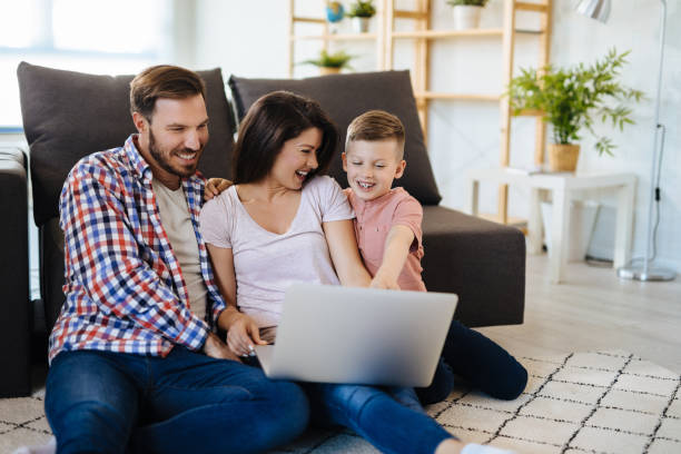 istock Happy family with little boy enjoying using laptop computer together 1158435840