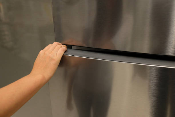 istock A hand is opening a refrigerator door 1158438627