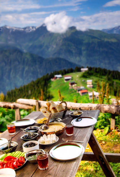 Delicious breakfast with landscape view in Pokut Plateau, Camlıhemsin, Rize, Turkey Close-up of a Turkish breakfast with various colorful foods and Black Sea Region food muhlama or kuymak (Turkish Cheese Fondue) with nature landscape view at Pokut Highland in Çamlıhemşin, Rize in Blacksea region of Turkey black sea photos stock pictures, royalty-free photos & images
