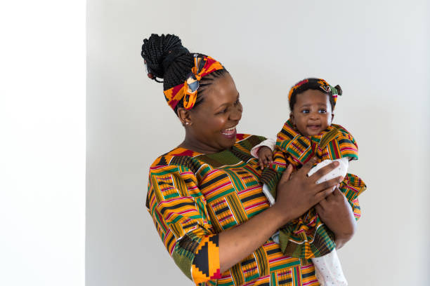 istock Happy mother looking at cute daughter against wall 1158448115