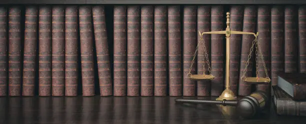 Photo of Low key filter law bookshelf with wooden judge's gavel and golden scale, 3D Rendering