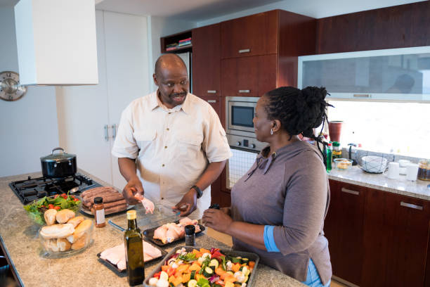 istock Mature couple talking while preparing food at home 1158448375