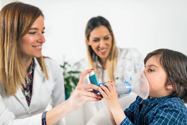 arzt hilft kleinem jungen mit inhalator - asthmatic child asthma inhaler inhaling stock-fotos und bilder