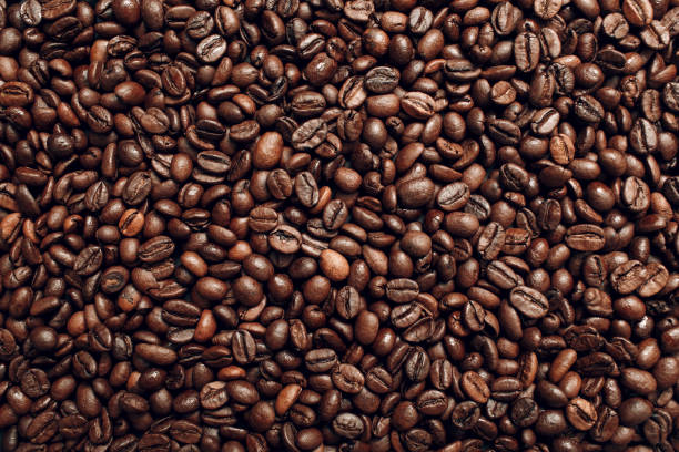 istock Roasted coffee beans brown seeds texture background wallpaper. Top view. 1158451745