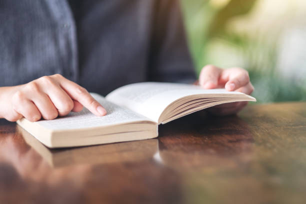 istock a woman holding and reading a book 1158453154