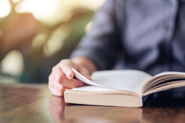 istock a woman holding and reading a book 1158453214