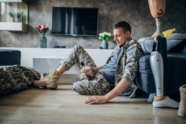 istock Depressed soldier with amputee leg drinking alcohol 1158454105