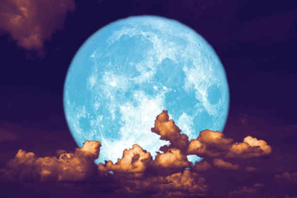 istock blue strawberry moon back on silhouette heap cloud on night sky 1158455396