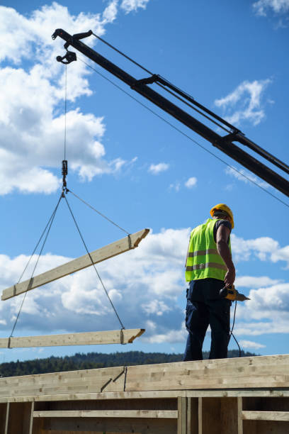 istock Construction worker standing on a wooden house construction site 1158455872