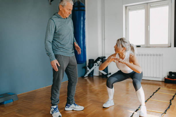 istock Senior man exercising with his personal trainer 1158457180