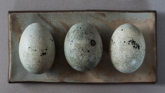 Three century eggs on a small ceramic plate