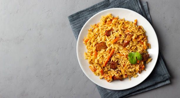 pilaf da riso, verdure e carne in un piatto su sfondo grigio. - flavored rice foto e immagini stock