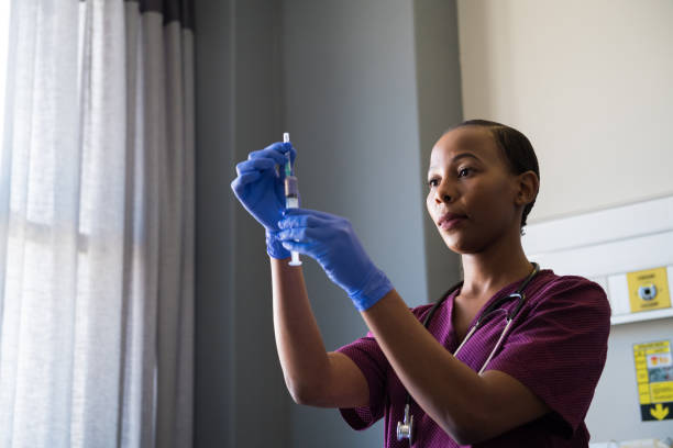 Confident female nurse holding syringe in ward
