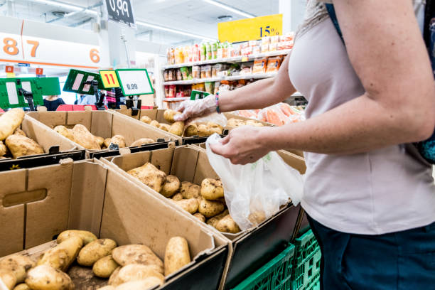 istock Woman in Hypermarket Choosing Fresh Raw Potatoes 1158462441