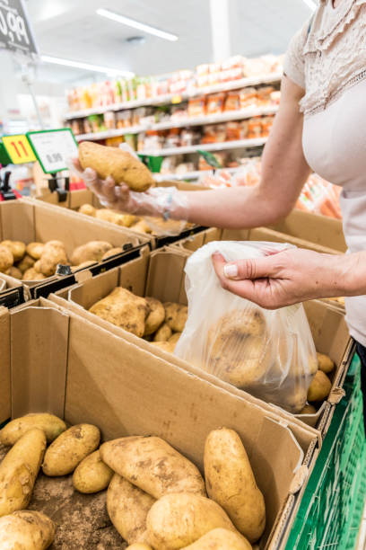 istock Woman in Hypermarket Choosing Fresh Raw Potatoes 1158462447