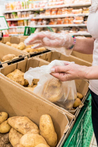 istock Woman in Hypermarket Choosing Fresh Raw Potatoes 1158462458