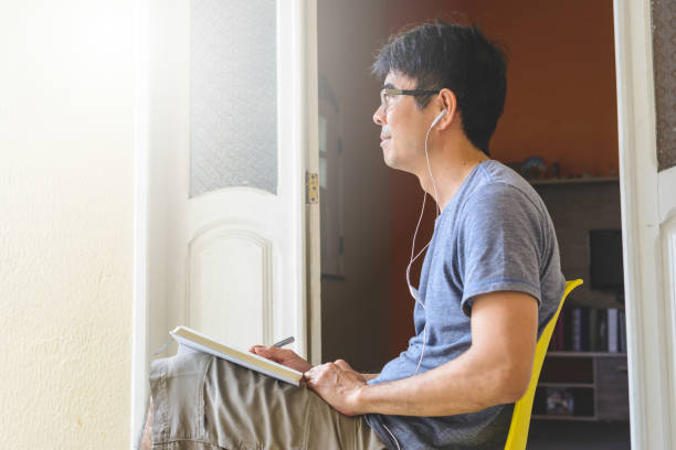 Asian man meditating and writing gratitude journal