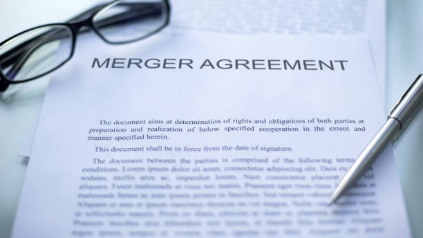 istock Merger agreement lying on table, pen and eyeglasses on official document 1158466276
