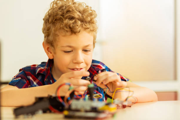 istock Nice pleasant boy holding two wires together 1158467529