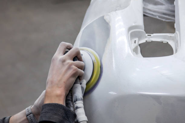 istock Preparation for painting a car element using sander and putty by a service technician leveling out before applying a primer after damage to a part of the body in an accident in the vehicle workshop 1158467756