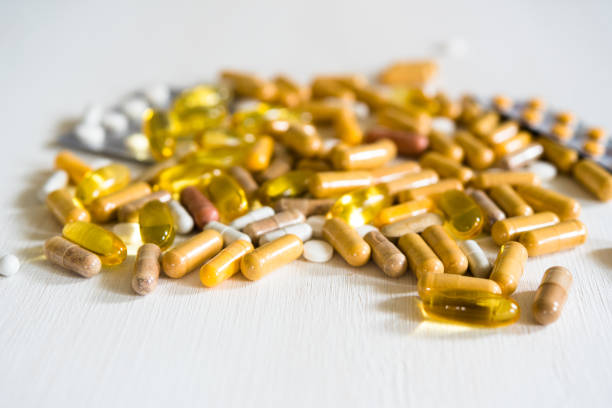 istock Different pills and capsules on wooden table 1158469215