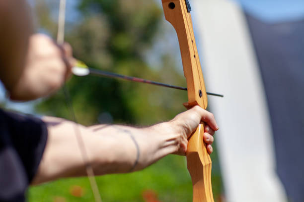 istock Archer holding wooden bow and aiming at target 1158469324